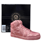 The AJ-1 Pink Shimmer Sneaker Candle (On Backorder), hand poured with all-natural wax, is displayed in front of a black Custom Candle Co. box featuring gold branding.