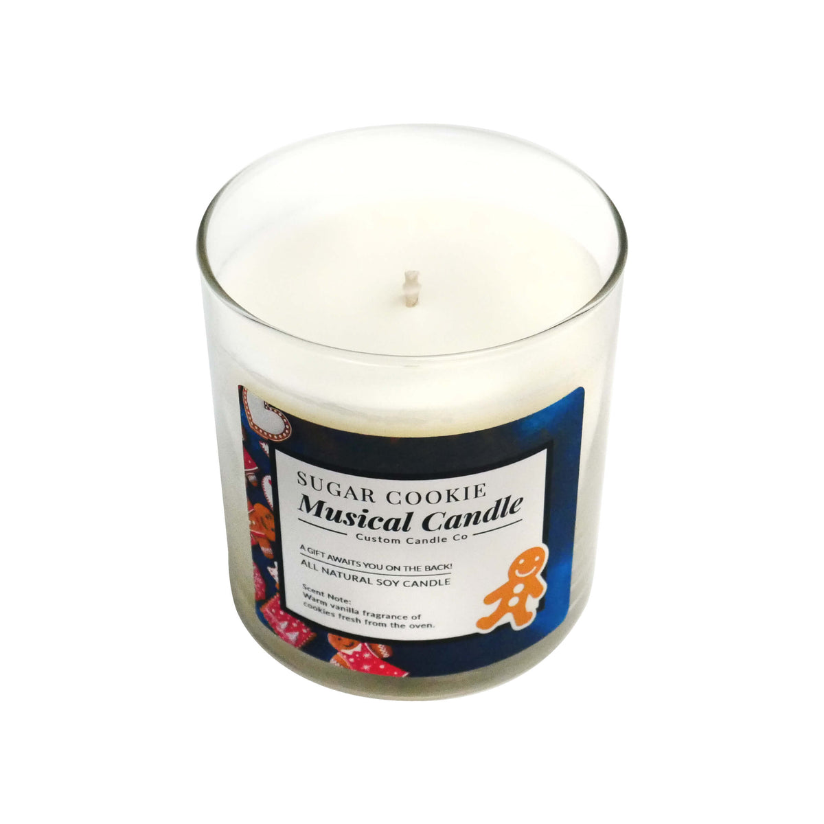 The Musical Holiday Candle – Sugar Cookie is a white soy candle in a clear glass jar, labeled with a gingerbread man graphic—perfect for anyone who loves scented musical Christmas candles.