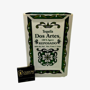 The Recycled Ceramic Tequila Candle – Flat Cut features a rectangular ceramic bottle with green patterns, made from coconut-apricot wax for sustainability, and comes with a black "Custom Candle Co." matchbox.